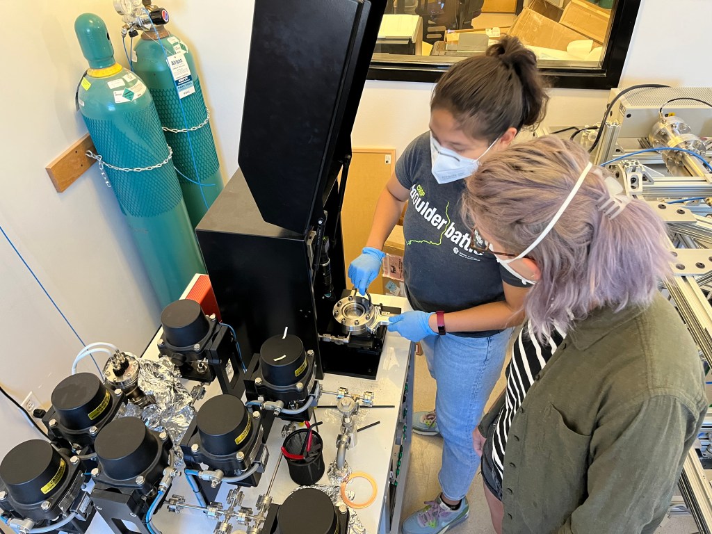 Two scientists working on a noble gas analysis line