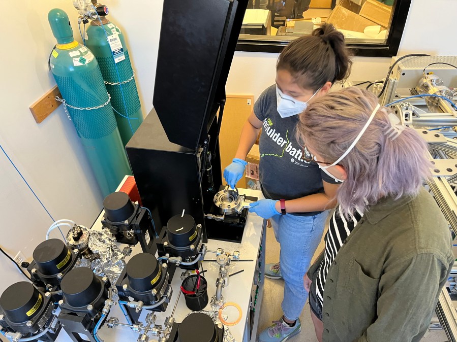 Two scientists working on a noble gas analysis line