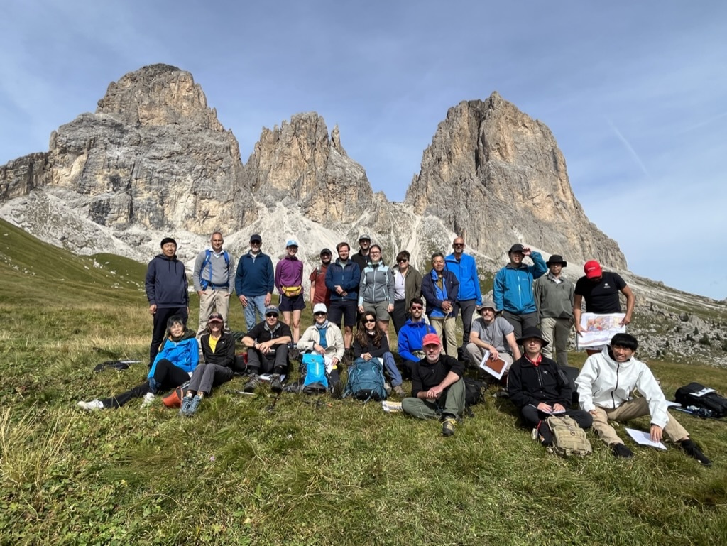 Geologists posing in front of large cliffs in the Dolomites