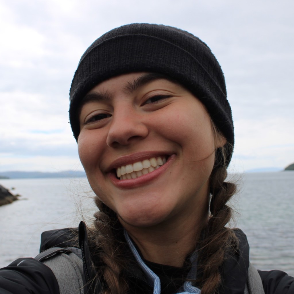 Kaitlyn smiling with water and sky behind her